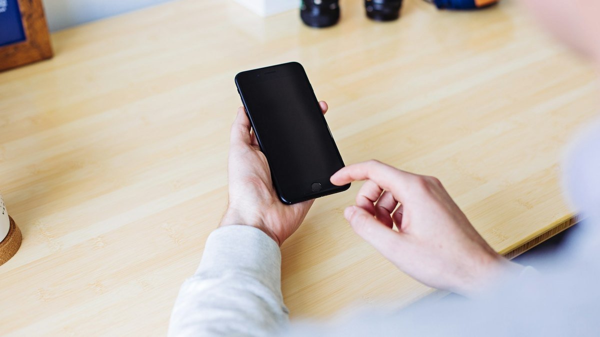 Representative photograph of a hand holding a smartphone for online activity.